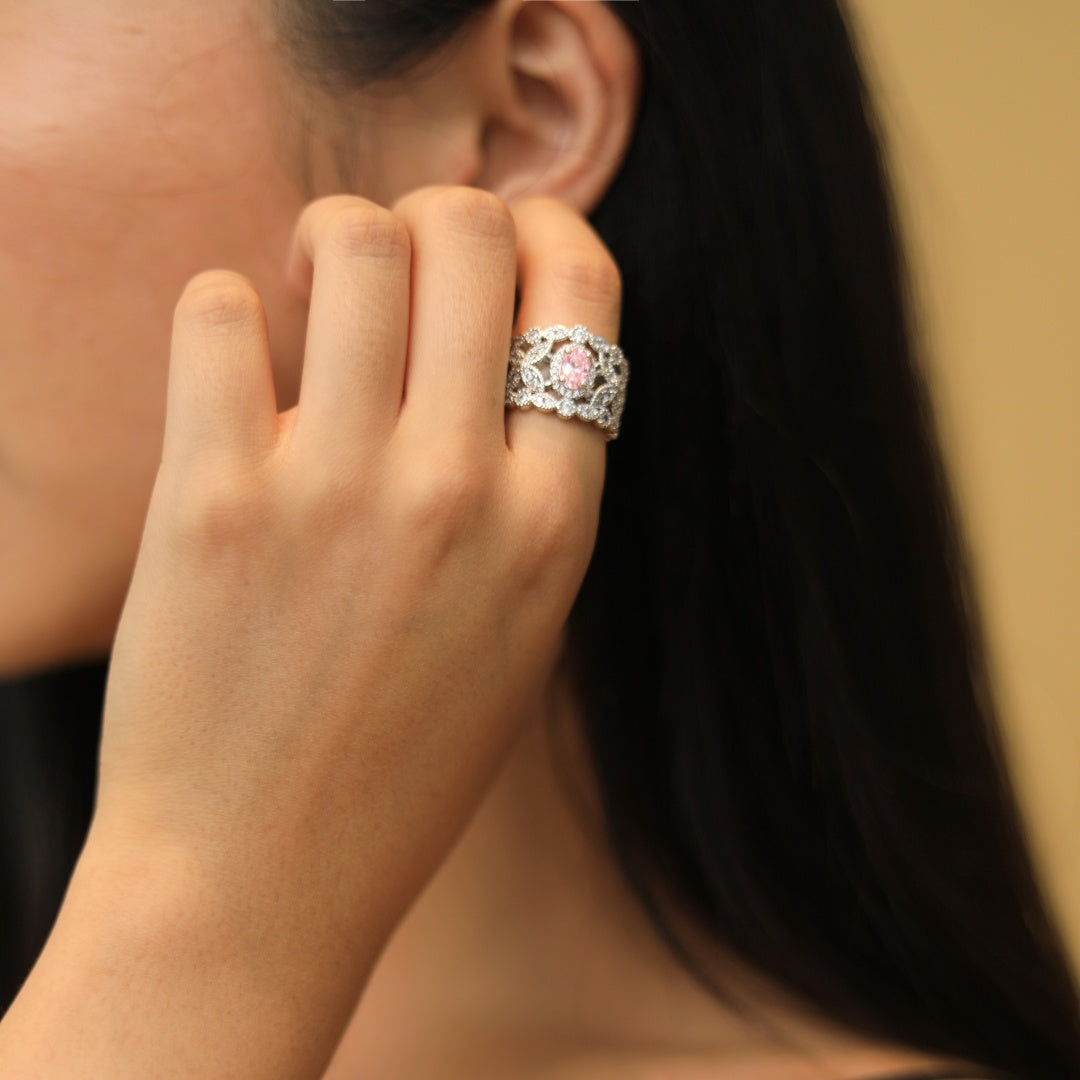 Anel vazado com um diamante rosa como pedra principal.